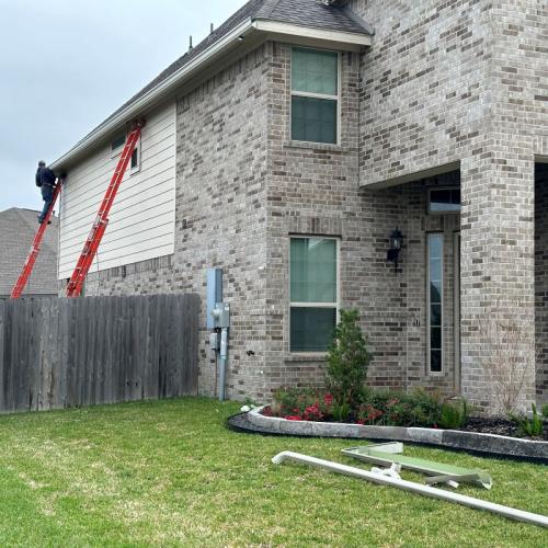 Yard Works men installing new gutters on house in Friendswood