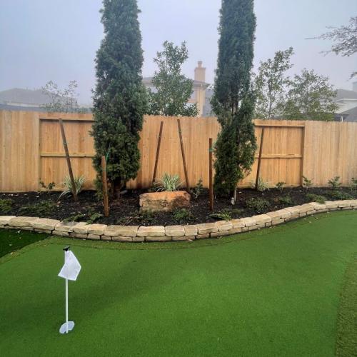 new turf putting green and trees installed in backyard